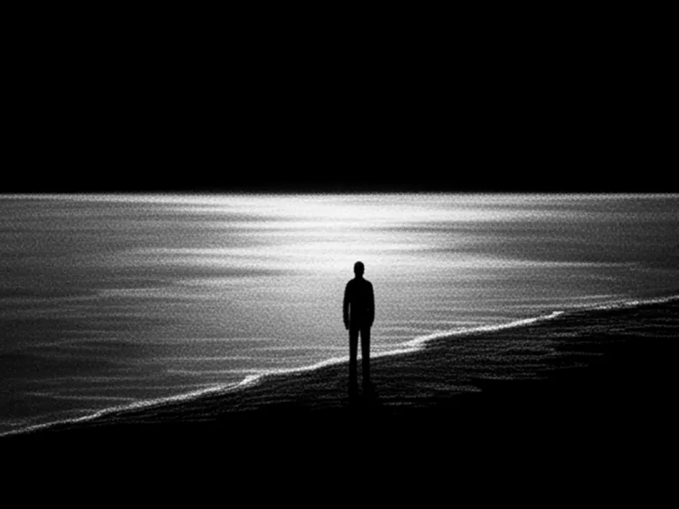 A figure at the shoreline with light running across the water
